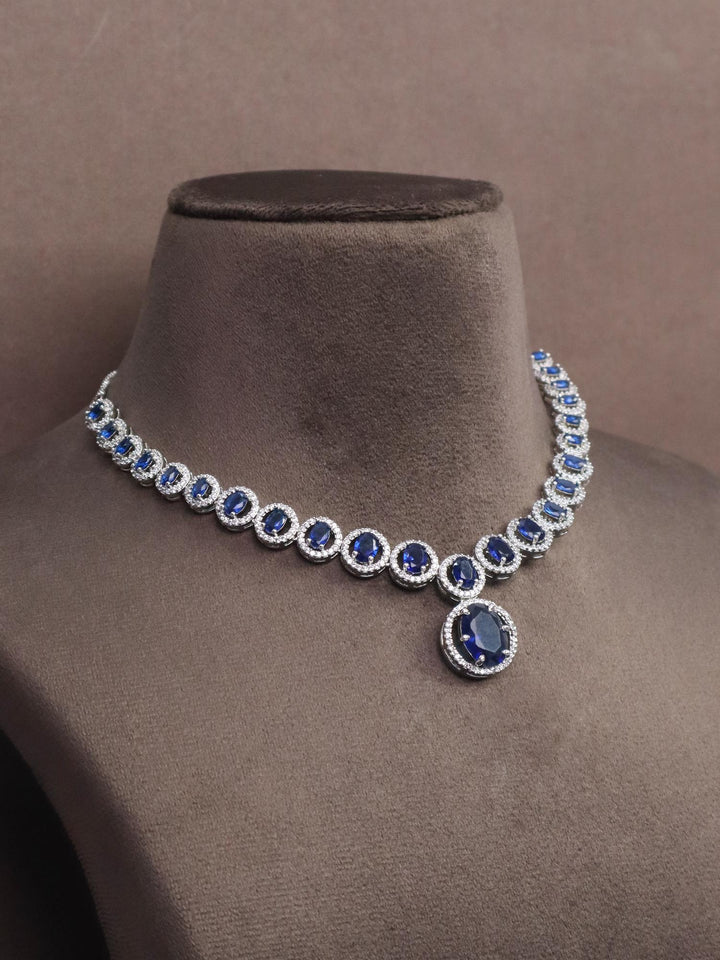 a closeup image of Dazzle Blue Sapphire Diamond Necklace Set  by Live Some India on a brown dummy 