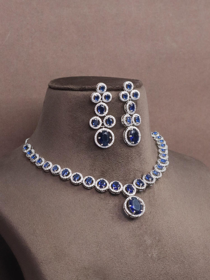 A closeup image of Dazzle Blue Sapphire Diamond Necklace Set -1 by Live Some India on a brown dummy 