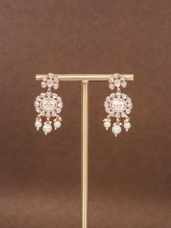 Dhariya Kundan Polki & White Meenakari Dangle Earrings on earring stand with brown background