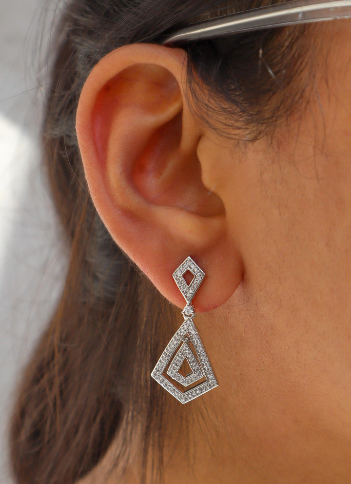 A closeup image of a girl wearing Diamond Dangler Earrings by Live Some India 