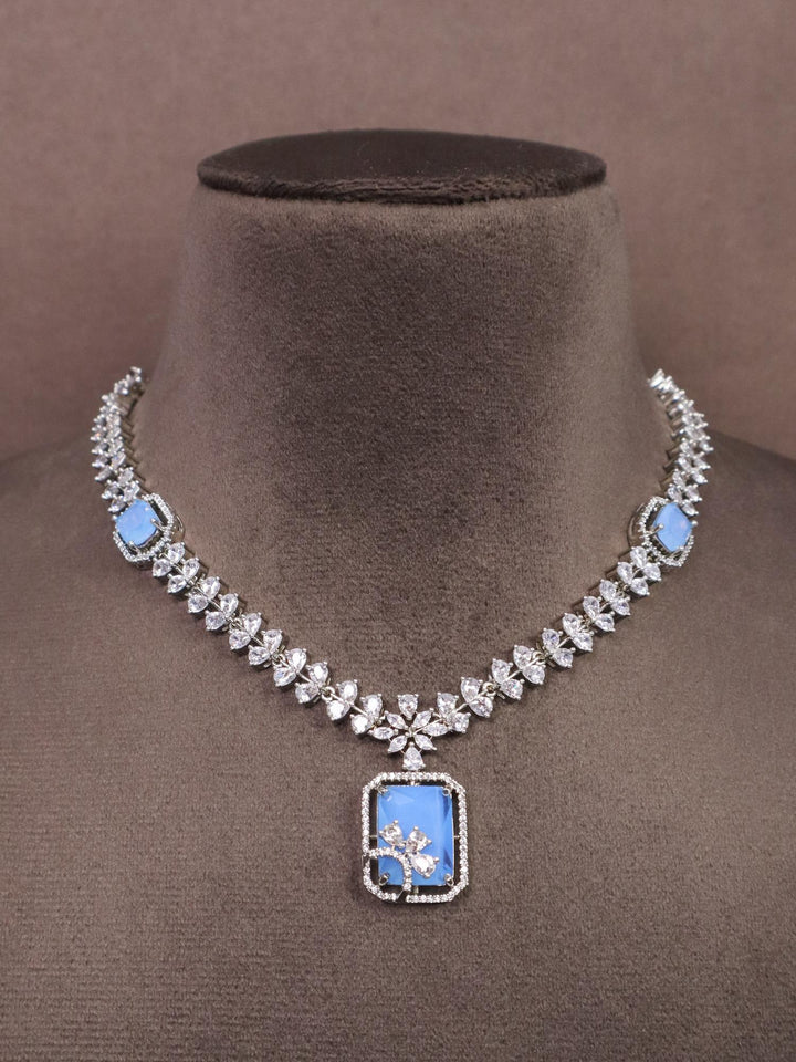 A closeup image of Elegant Blue Diamond Necklace by Live Some India on a brown dummy 