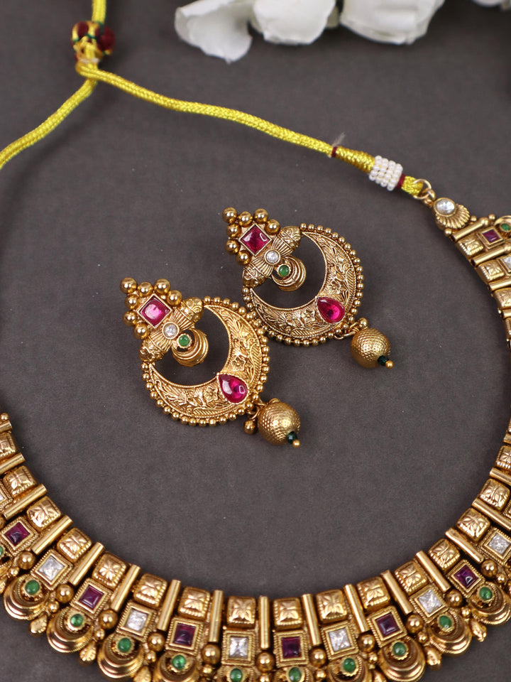 A closeup image of Exquisite 18K Gold Plated Temple Earrings-4 by Live Some India on a grey background with flowers 