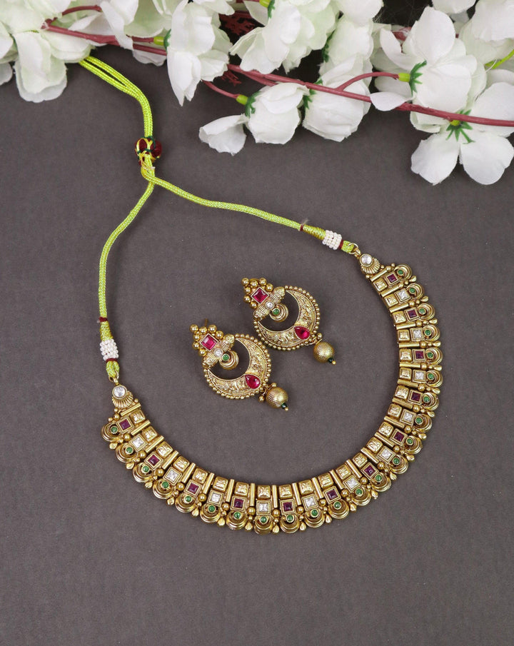 A closeup image of Exquisite 18K Gold Plated Temple Necklace -4 by Live Some India on a grey background with flowers 