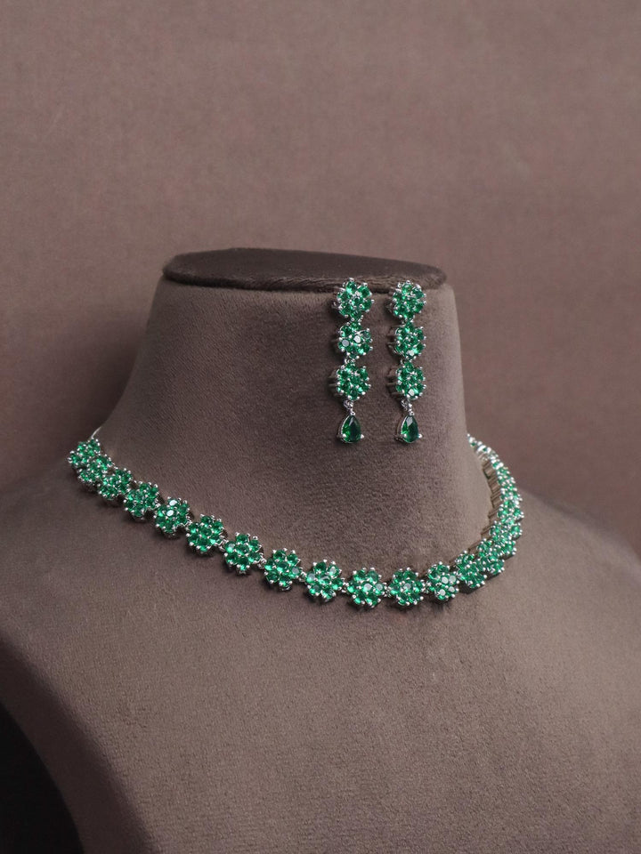 A closuep image of Flora Emerald Diamond Necklace set by Live Some India on a brown dummy 