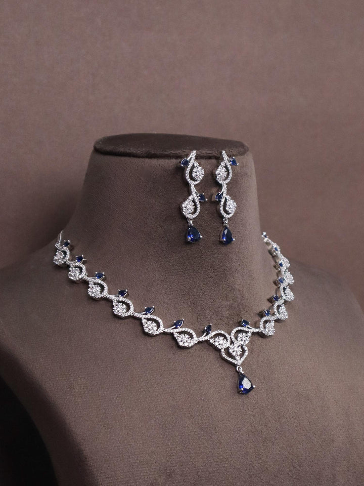 A closeup image of Floral Blue sapphire Diamond Necklace Set by Live some India on a brown dummy