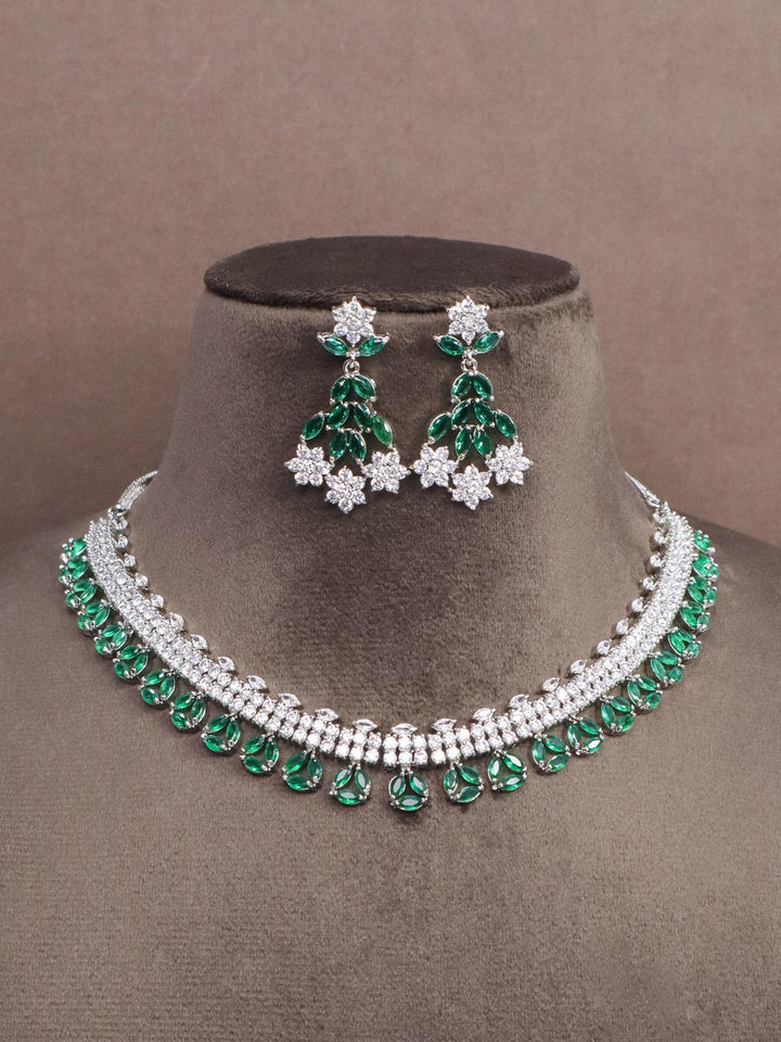 A closeup image of Floral Green Emerald Diamond Necklace Set-1 by Live Some india on a brown dummy 