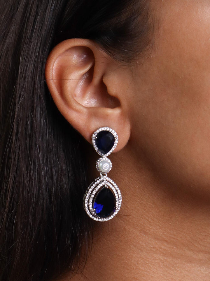 A closeup image of a firl wearing Grand Blue Sapphire Diamond Earrings by Live Some India 