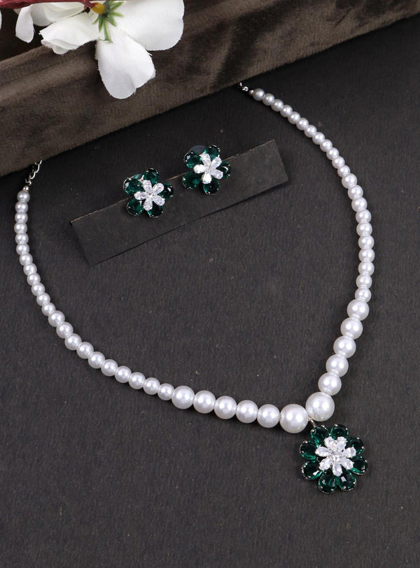 A closeup image of Green Flower Pendant Pearl Necklace Set by Live Some India on a black background 