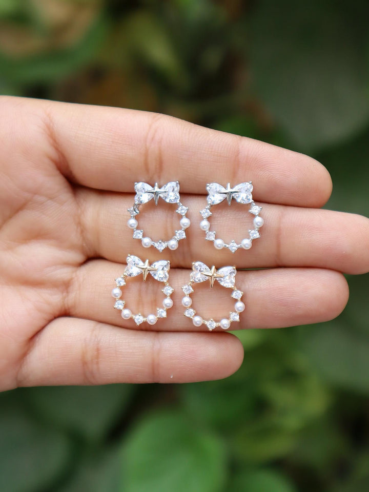 A closeup image of Heart Bow Holy Earrings -1 by Live Some India showing its variants 