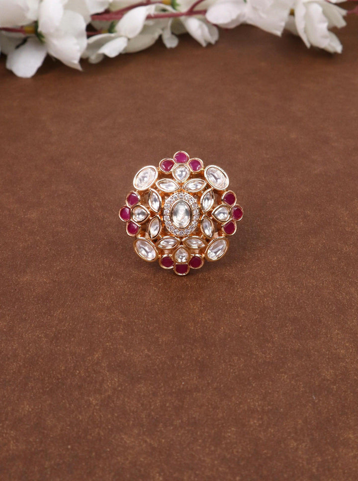 A closeup image of Inaya Red Kundan Polki Ring -1 by Live Some India on a brown background 