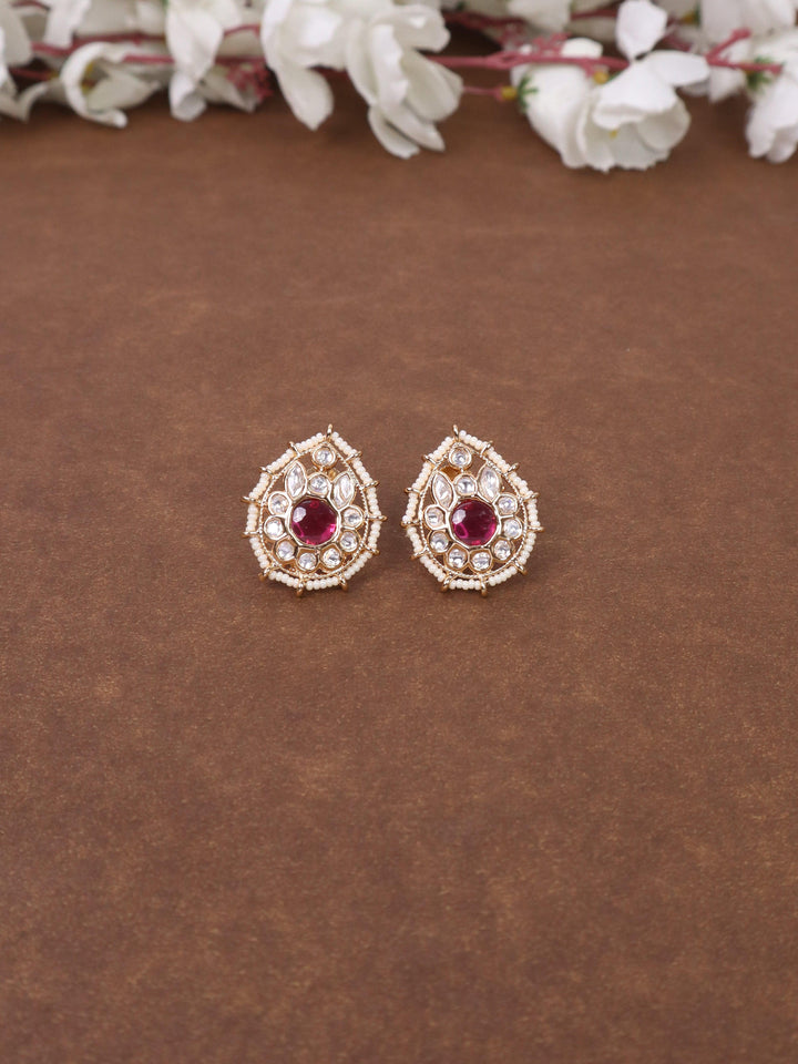 A closeup image of Jaani Red Kundan Polki Stud Earrings by Live Some India on a brown background 