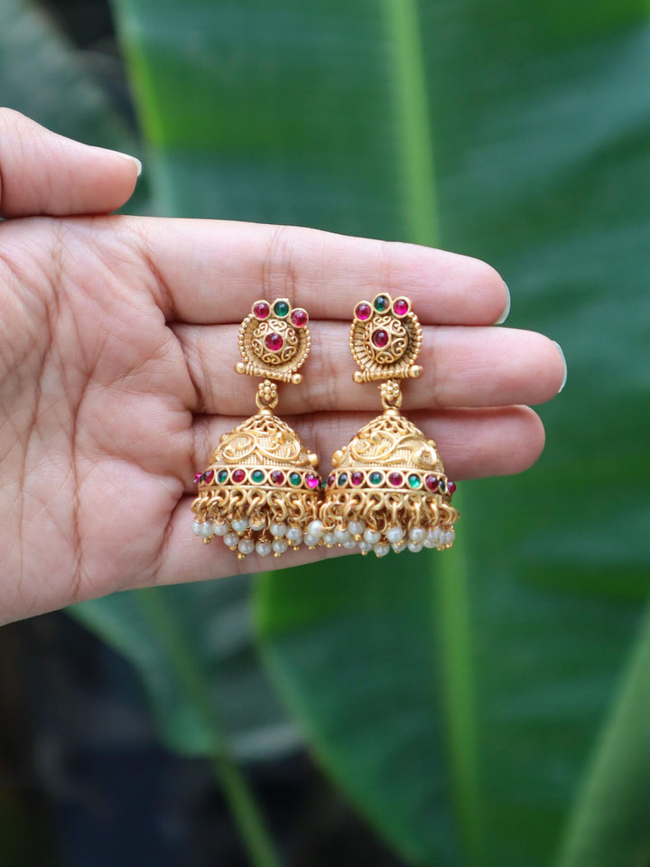 Keerthana Temple Jewellery Jhumka Earrings by Live Some India on hand with natural green leaves background