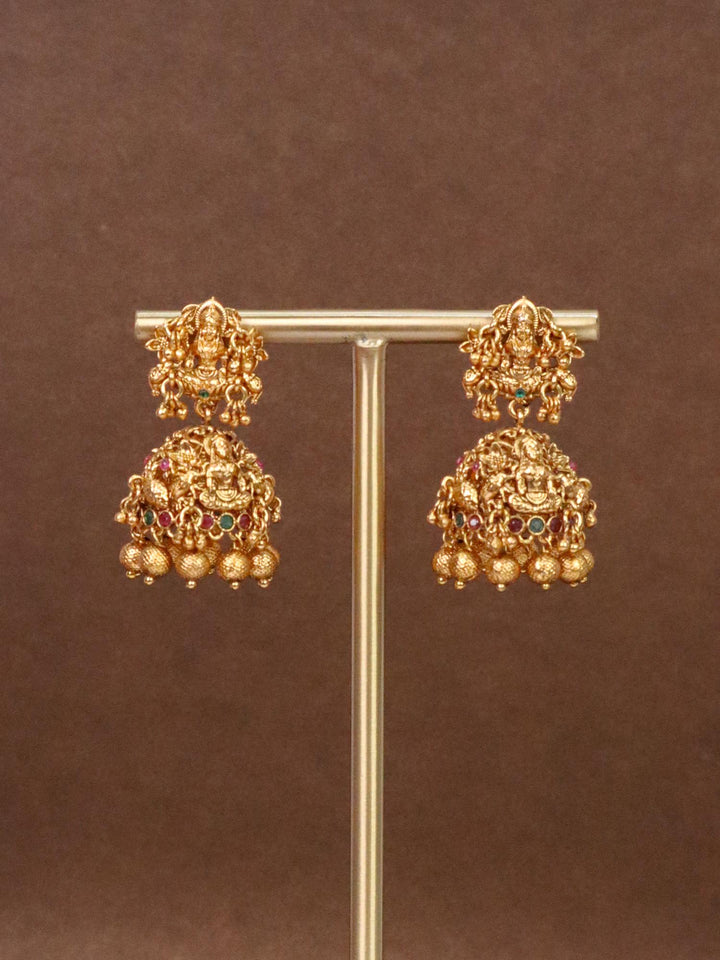 Laxmi Mata Designer Temple Jhumka Earrings by Live Some India on an earring stand with brown background