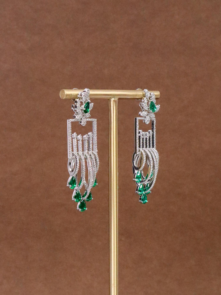 Side view of Manvi Designer Diamond Dangle Earrings by Live Some India on an earring stand with brown background