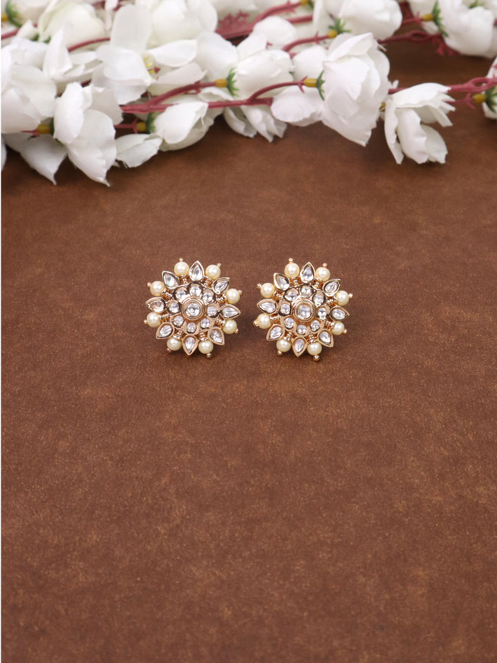 A closeup image of Maria Kundan Polki White Stud Earrings -1 by Live Some India on a brown background 