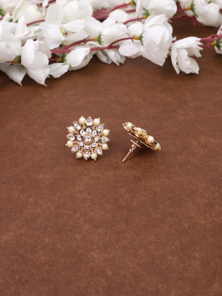 A closeup image of Maria Kundan Polki White Stud Earrings -1 by Live Some India on a brown background