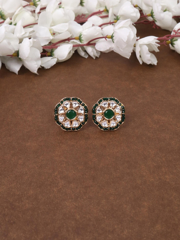 A closeup image of Maya Beaded Green Kundan Polki Stud Earrings by Live Some India on a brown background 