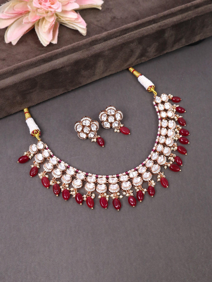 A coseup image of Maya Red Kundan Polki Necklace Set by Live Some India on a brown dummy 