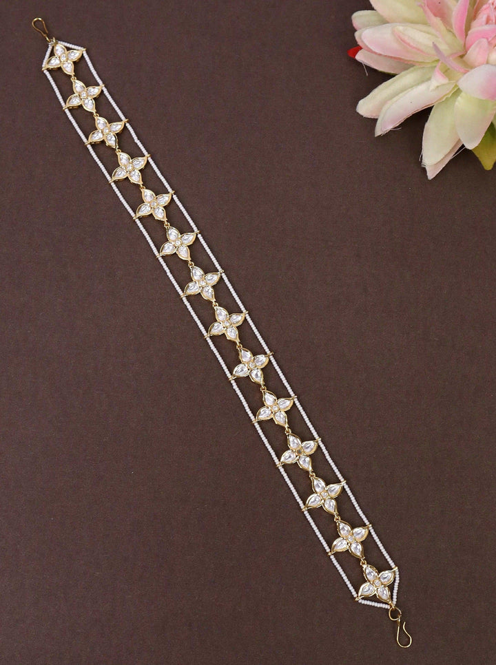 A closeup image of Mayra White Beaded Floral Matha Patti by LIve Some India on a brown background