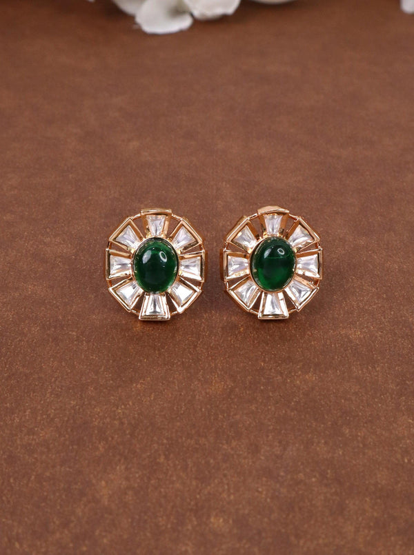 A closeup image of Mira Kundan Polki Stud Earrings by Live Some India on a yellow satin cloth with flowers