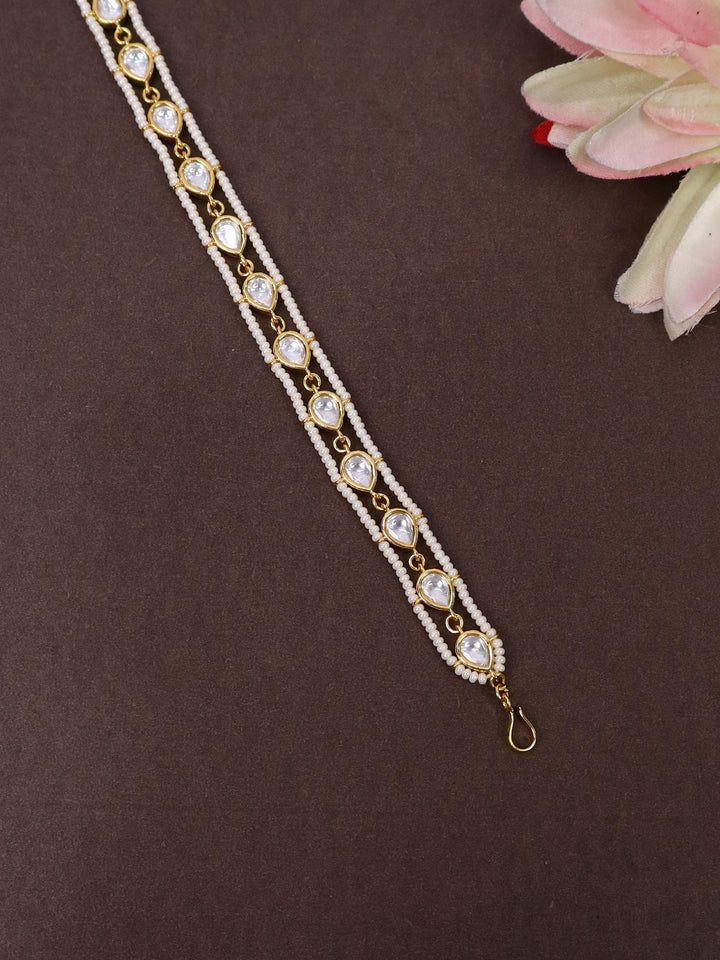 A closeup image of Mohini White Beaded Drop Matha Patti -1 by Live Some India on a brown background 