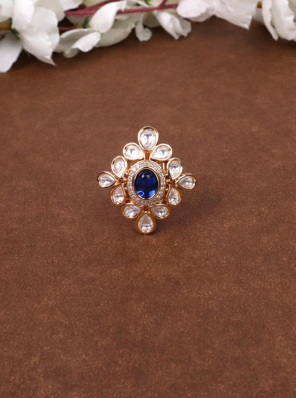 A closeup image of Naira Blue Kundan Polki Ring -1 by Live Some India on a brown background