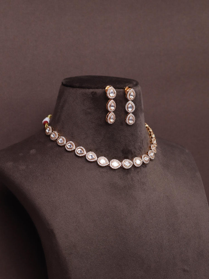 A closeup image of Nira Single Line Kundan Polki Necklace Set -3 by Live Some India on a brown background
