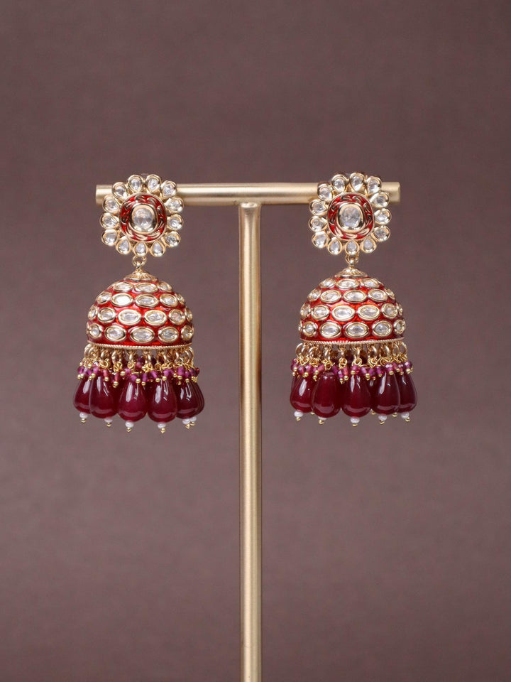 A closeup image of Niyara Kundan Polki Jhumka Earrings -1 by Live Some India on a brown background 