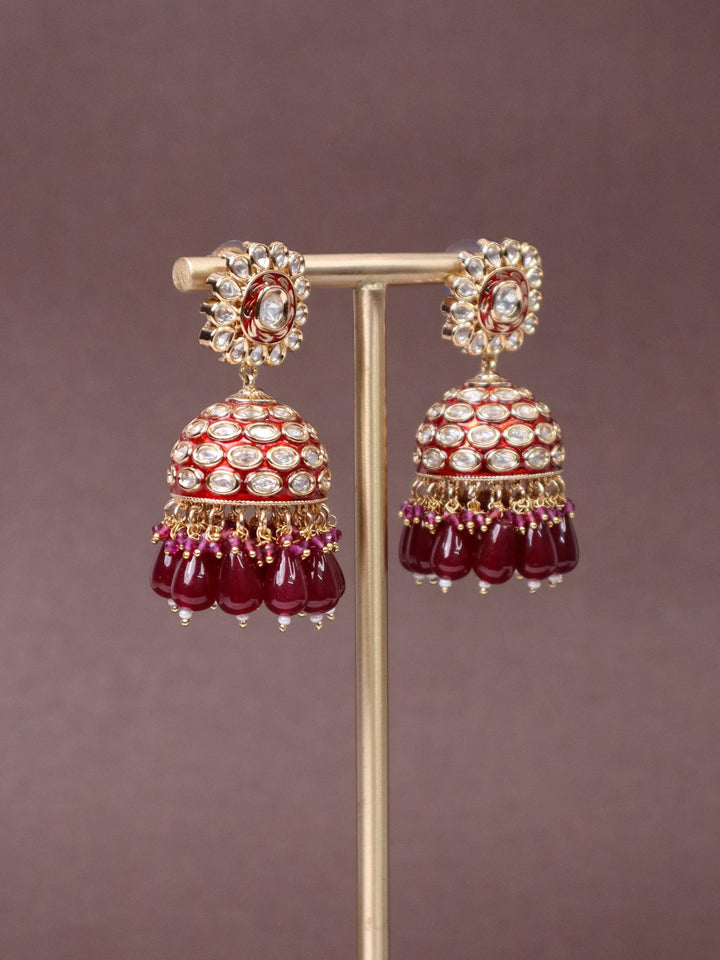 A closeup image of Niyara Kundan Polki Jhumka Earrings -2 by Live Some India on a brown background 