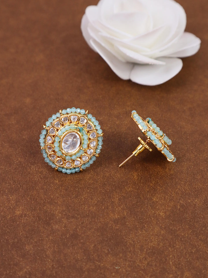 A closeup image of Oval Dainty Kundan Polki Stud Earrings 1 by Live Some India on a brown background with a white rose