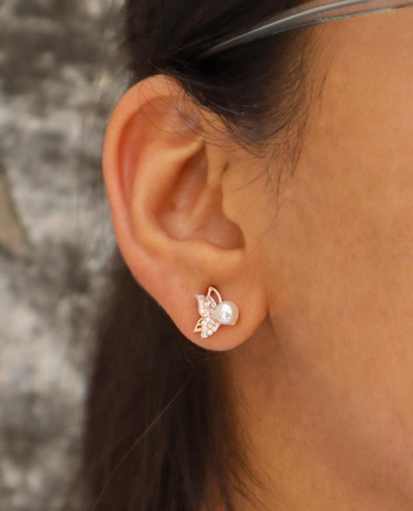 A closeup image of a girl wearing Pearl Butterfly Earrings by Live Some India 