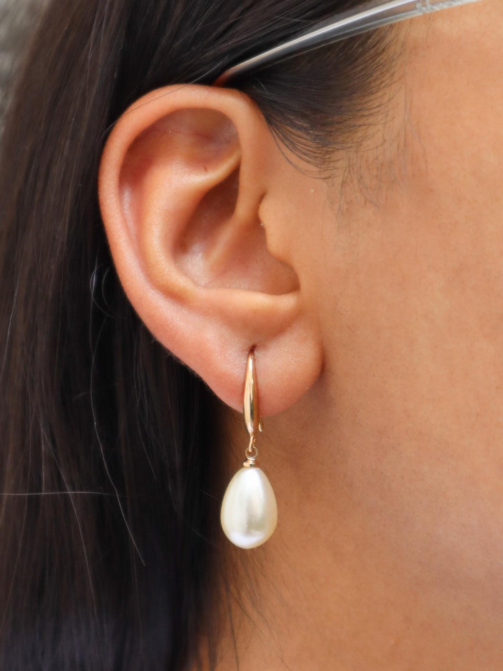 A closeup of a girl wearing Pearl Drop Earrings by Live Some India