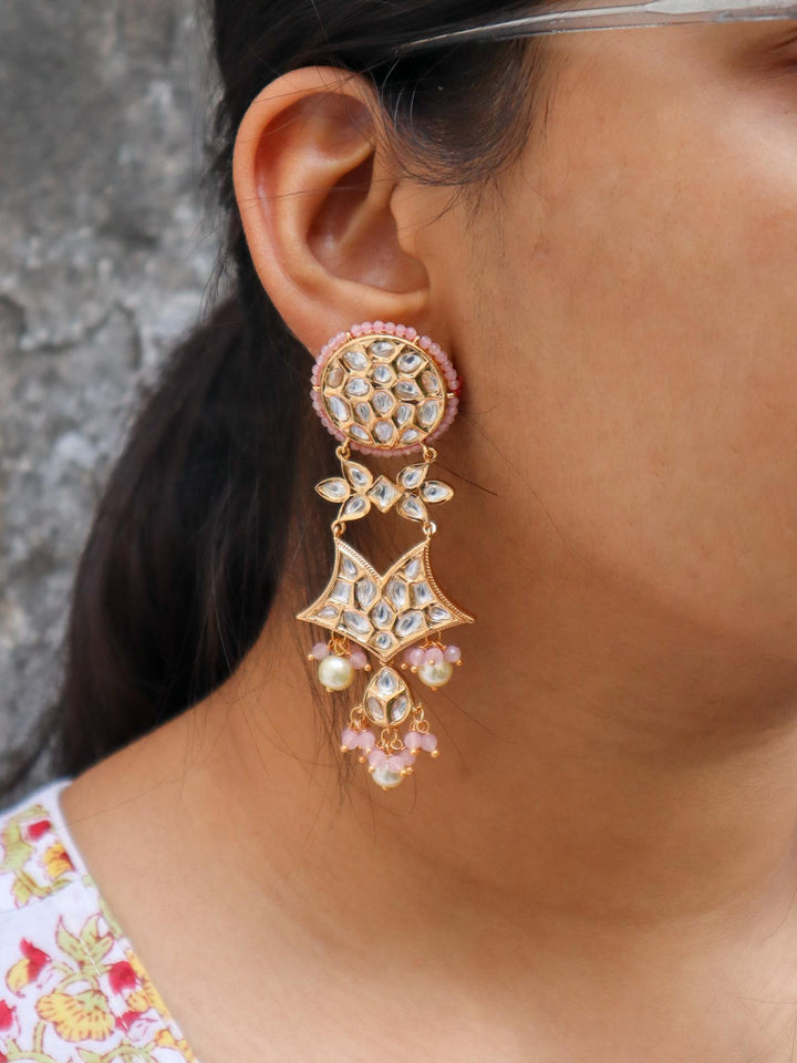 A closeup image of a girl wearing Pink Star Kundan Polki Dangler Earrings by Live Some India 