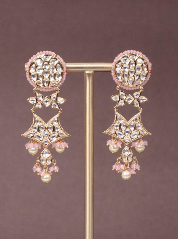 A closeup image of Pink Star Kundan Polki Dangler Earrings -1 by Live Some India on a brown background