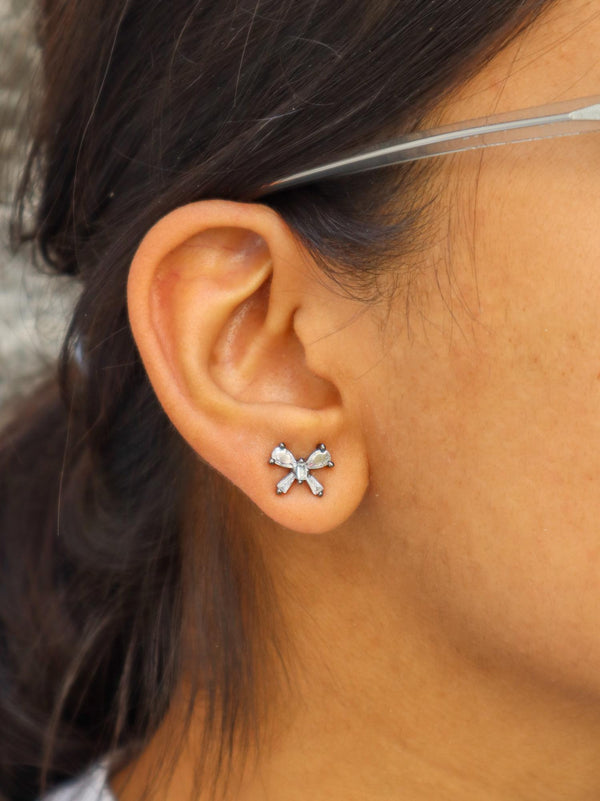 A closeup image of a girl wearing Ribbon Earrings by Live Some India 