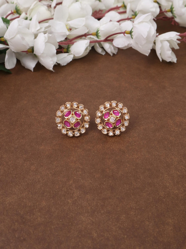 A closeup image of Siya Pink Kundan Polki Stud Earrings by Live Some India on a brown background 