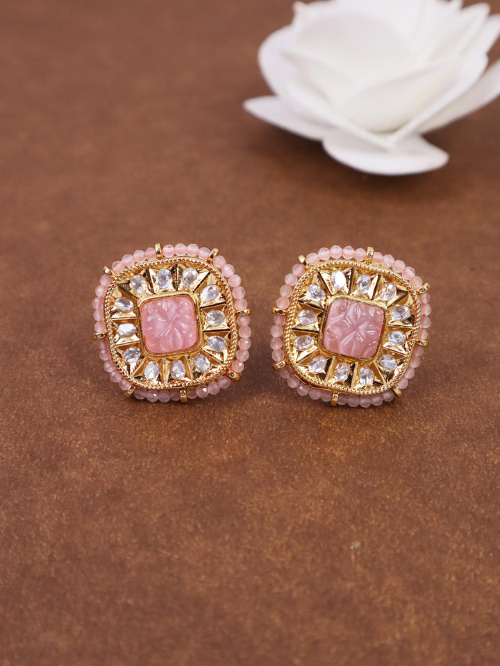 A closeup image of Soft Pink Kundan Polki Stud Earrings by Live Some India on a brown background with a white rose