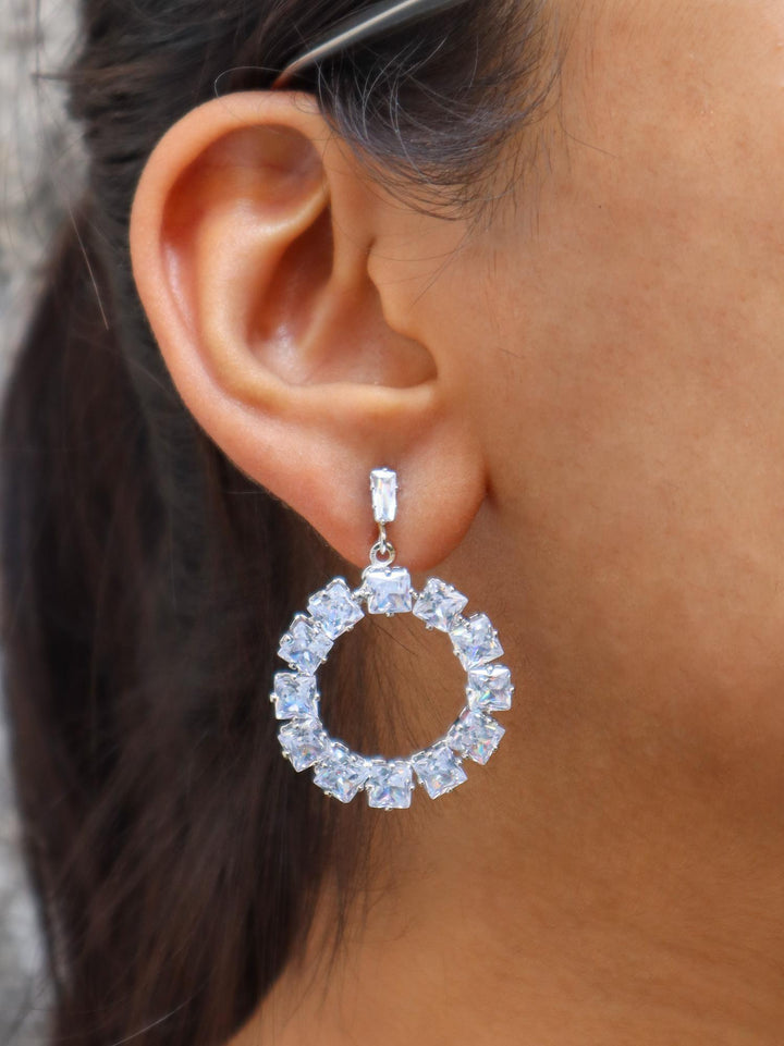 A closeup image of a girl wearing Solitaire Dangler Earrings by Live Some India 