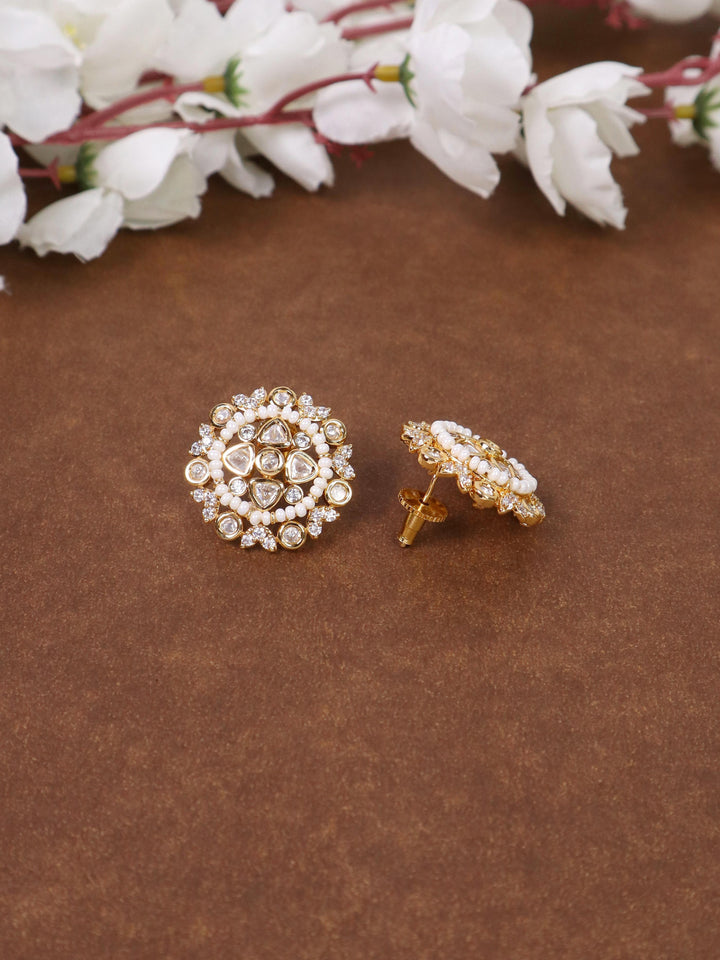 A closeup iamge of Soni Kundan Polki White Stud Earrings -1 by Live Some India on a brown background with flowers 