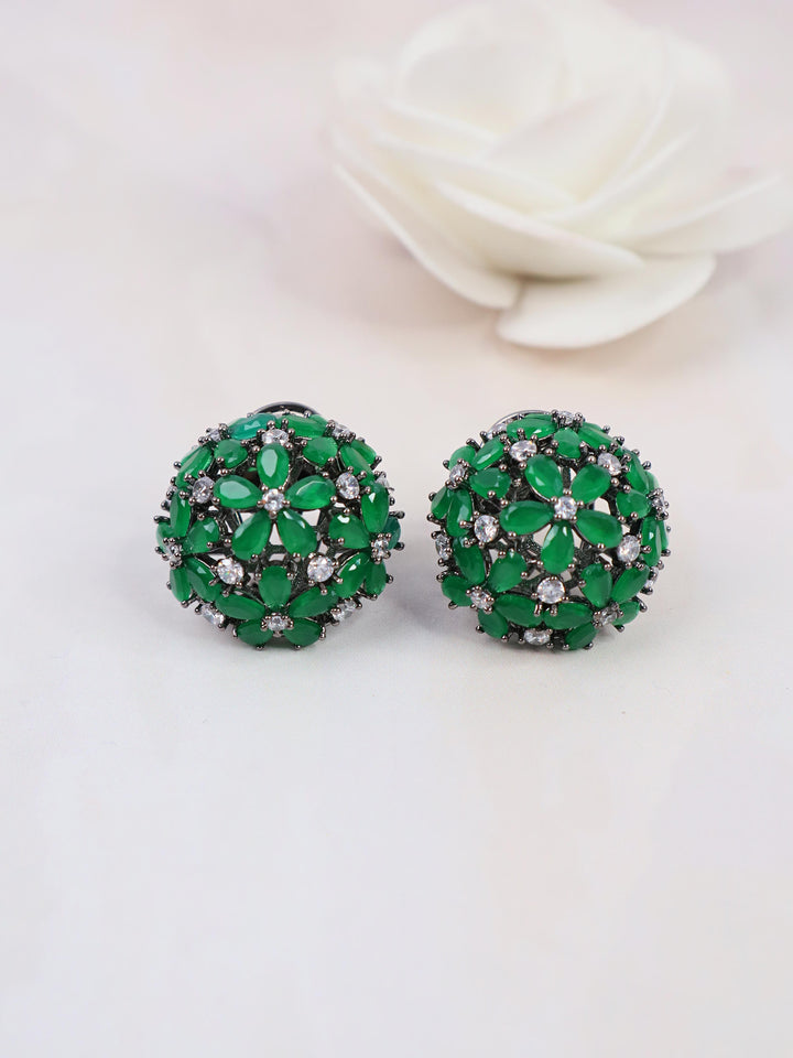 A closeup image of Starry Green Contemporary Stud Earrings by Live Some India on a white background with a white rose