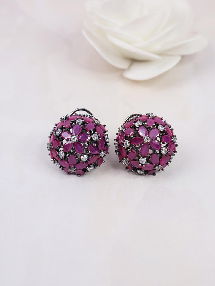 A closeup image of Starry Purple Contemporary Stud Earrings by Live Some India on a white background with a white rose