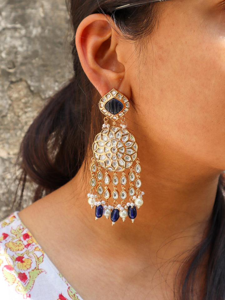 A closeup image of a girl wearing Statement Blue Kundan Polki Dangler Earrings by Live Some India 