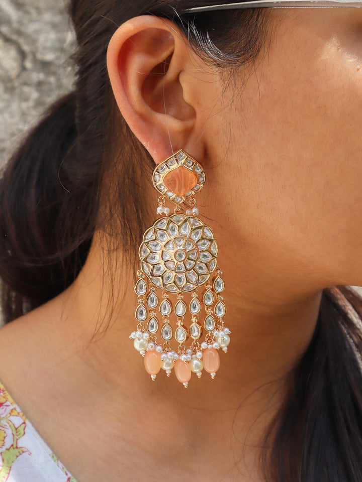 A closeup image of a girl wearing Statement Peach Kundan Polki Dangler Earrings  by Live Some India 