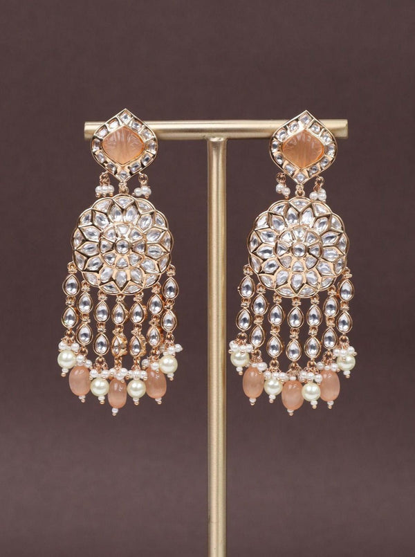 A closeup image of Statement Peach Kundan Polki Dangler Earrings -1 by Live Some India on a brown background 