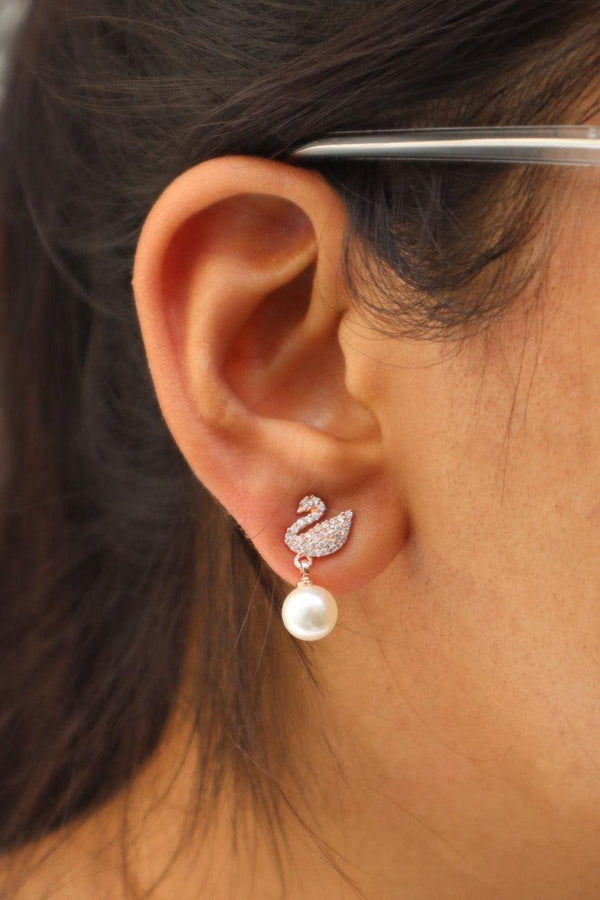 A closeup image of a girl wearing Swan Rose Gold Earrings by Live Some India 