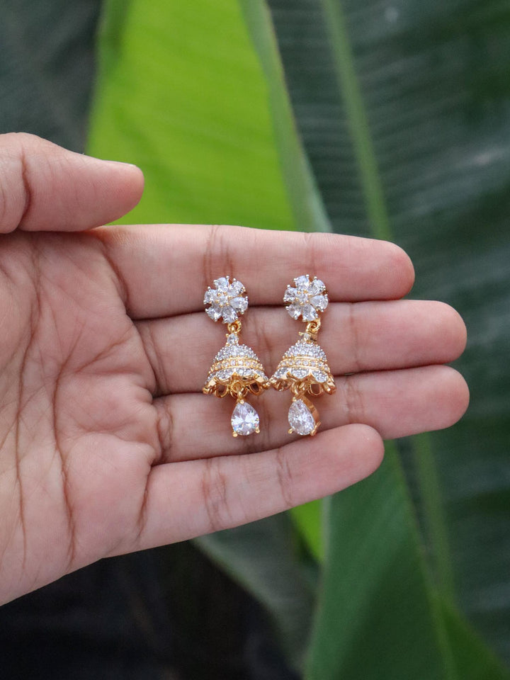 Tia Diamond Small Dangle Jhumka Earrings on hands with a natural green leaves background