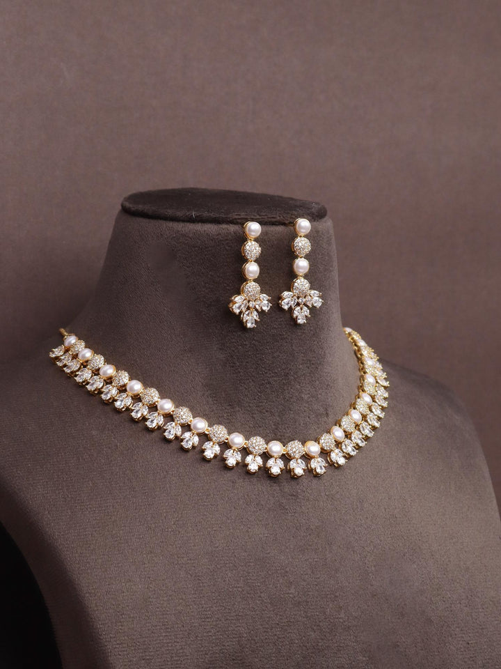 A closeup image of Tulip Golden Pearl Necklace Set by Live Some India on a brown dummy 