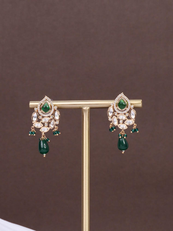 A closeup image of Urja Green Pearl Kundan Polki Earrings by Live Some India on a brown background 