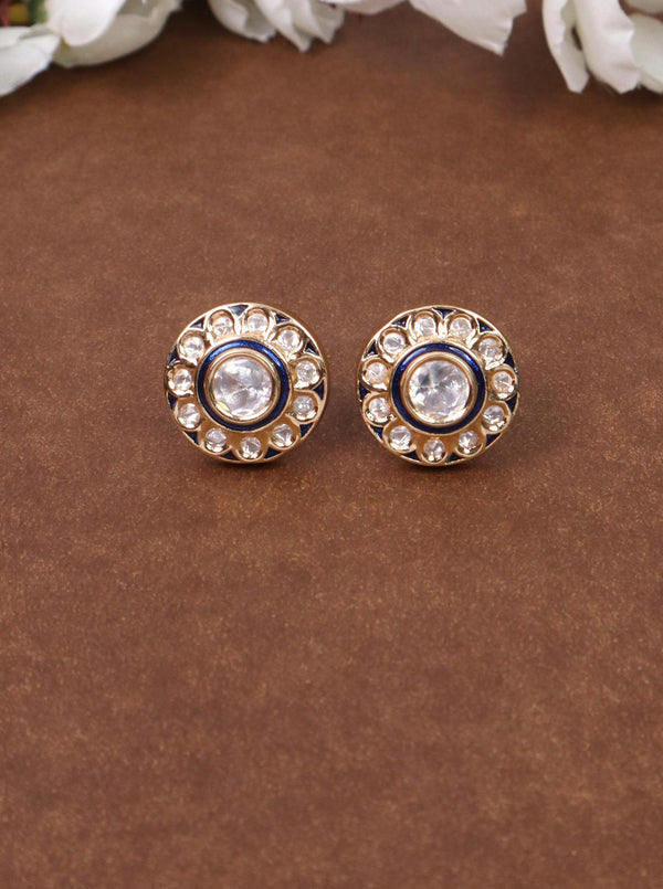 A closeup image of Uyi Menakari Blue Kundan Polki Stud Earrings -1 by Live Some India on a brown background 