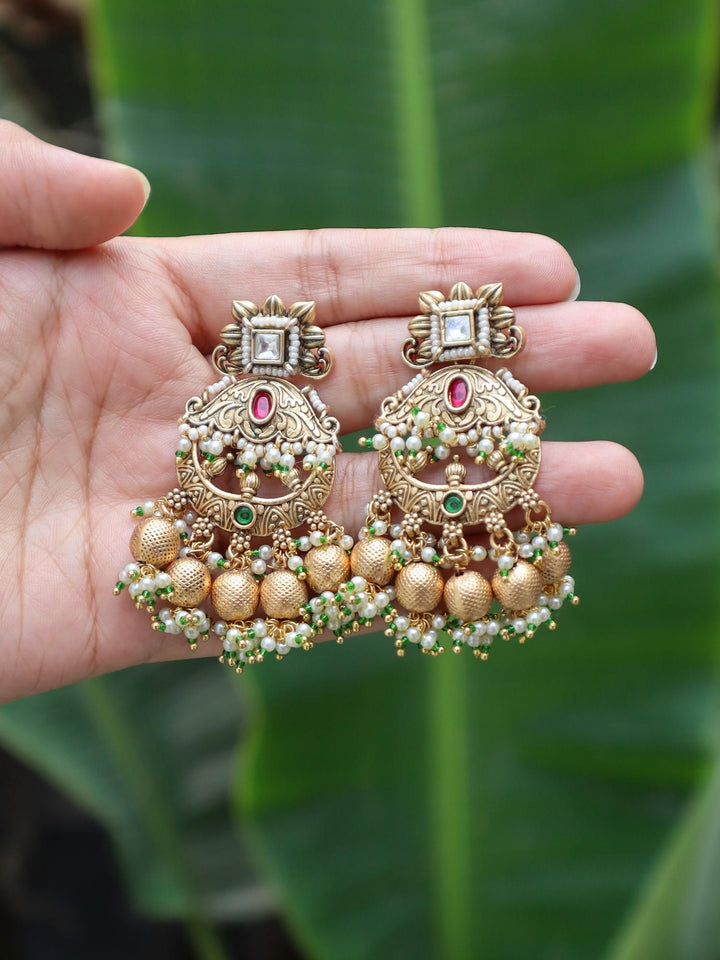 Vaishnavi Dangle Earrings by Live SOme India on hands with green leaves bacground